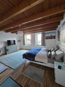 a bedroom with a large bed and a wooden ceiling at Auszeit Tor zur Eifel in Euskirchen