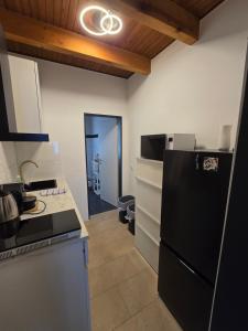 a kitchen with a black refrigerator and a stove at Auszeit Tor zur Eifel in Euskirchen