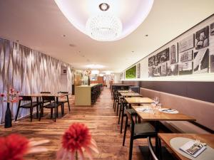 a dining room with wooden tables and chairs at Kreuz Bern Modern City Hotel in Bern