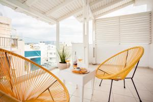a balcony with a table and chairs and a view at Coral Hotel - Hotelia Hospitality Group in Ierapetra