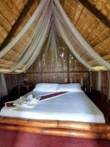 a bedroom with a bed with a mosquito net at Mudita Glamping and Villas Tarlac in Mababanaba