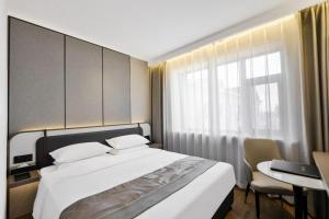 a bedroom with a bed and a desk and a window at 黑河易达酒店 in Heihe +33 photos