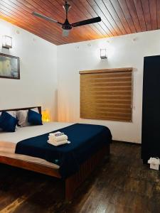 a bedroom with a bed with a ceiling fan at Nature Land in Alleppey +26 photos