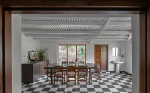a dining room with a table and chairs at Hideaway Art Residency in Ooty