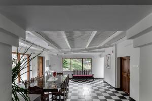 a room with a table and chairs and a window at Hideaway Art Residency in Ooty