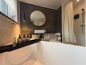 a bathroom with a tub and a sink and a mirror at Park Terrace Family Room in Glastonbury