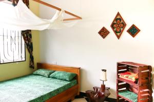 a bedroom with a bed and a window and a shelf at Rafiki Backpackers & Guesthouse in Moshi