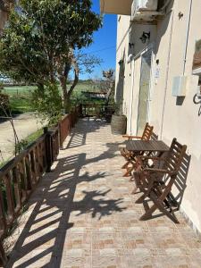 two wooden benches sitting outside of a building at Akrotiri Studios in Samothraki +6 photos