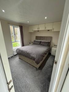 a bedroom with a large bed and a window at 136, Port Haverigg in Millom