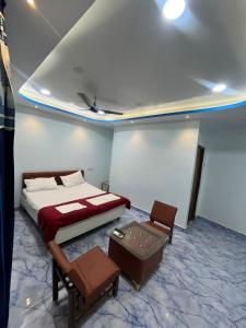 a bedroom with a bed and a table and chairs at Hotel Golden Palace in Chhatarpur