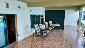 a patio with chairs and a table on a building at Rooms on ocean view in Grand-Baie