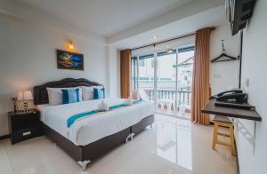 a bedroom with a bed and a desk and a window at TH beach hotel in Hua Hin