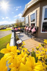 a group of benches on a deck with yellow flowers at 136, Port Haverigg in Millom