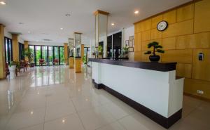 a lobby with a counter with a clock on the wall at TH beach hotel in Hua Hin
