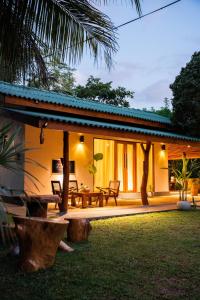 a house with a patio with a table and chairs at Zov Wild Yala in Kataragama