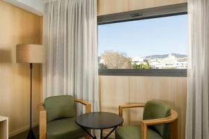 a room with two chairs and a table and a window at AC Hotel Sants by Marriott in Barcelona +44 photos