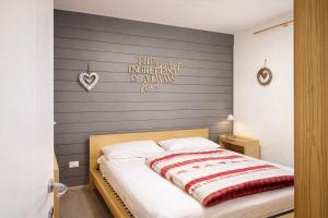 a bedroom with a bed with a heart sign on the wall at CASA 4 PIOPPI - Vista Lagorai e tranquillità a Cavalese - Dolomiti Affitti in Cavalese
