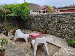 two chairs and a table in front of a stone wall at Chambre privée Orthez in Orthez