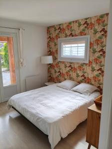 a bedroom with a large bed with a floral wallpaper at Chambre privée Orthez in Orthez