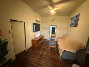 a living room with a couch and a ceiling fan at The Beach Shack Yeppoon in Yeppoon