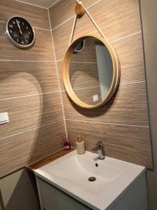 a bathroom sink with a mirror and a clock at Chez Val et Phil in La Voulte-sur-Rhône +20 photos