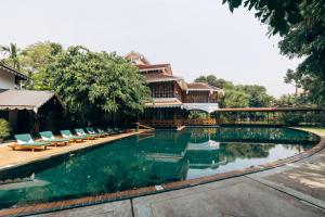 a swimming pool with chairs and a building at Governor's Residence in Yangon