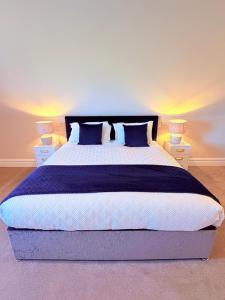 a bedroom with a large bed with blue pillows at Country View House in Milltown