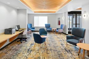 a waiting room with chairs and desks and a computer at TownePlace Suites Farmington in Farmington