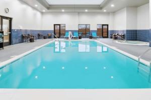 a swimming pool with blue water in a building at TownePlace Suites Farmington in Farmington