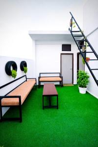 a room with two benches and green grass at Nexaura Stays in Indore