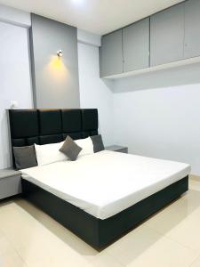 a bedroom with a large bed with a black headboard at Nexaura Stays in Indore