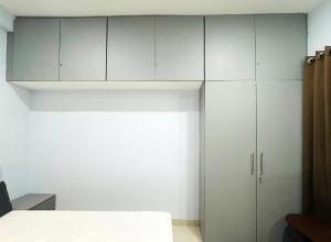 a bedroom with white cabinets and a bed in it at Nexaura Stays in Indore