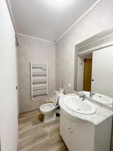 a white bathroom with a sink and a toilet at Studio 2 Résidence Eugénie in Eaux-Bonnes