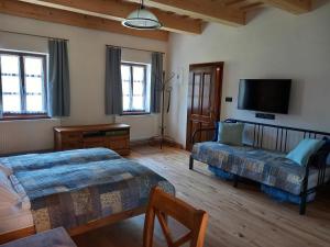 a bedroom with two beds and a flat screen tv at Lotrinský Apartmány in Hodruša