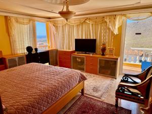 a bedroom with a bed and a flat screen tv at Villa Tenerife Sur in Adeje