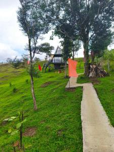 a path leading to a house in a field with trees at Mccp glamping and resort in Cavinti +5 photos