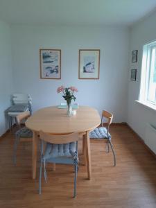 a dining room table with a vase of flowers on it at Nernesholmen in Nes
