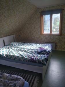 a bedroom with a bed with a comforter and a window at Nernesholmen in Nes