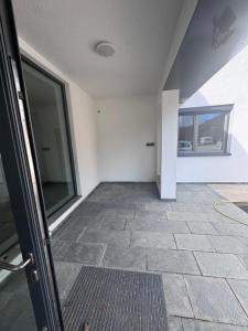 an empty room with a large window and a tile floor at Ferienapartments Sternen WOHN 7 in Baiersbronn