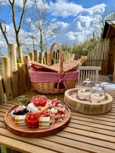 a table with two plates of food and a basket at Coeur de Lodge spa privatif in Cramoisy