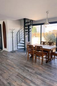 a dining room with a table and chairs and a staircase at Maison classée à 100m de l'océan in Mimizan-Plage