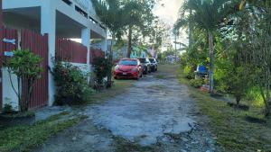 a dirt road with cars parked next to a house at Comfort Suites - Studio One in La Fargue