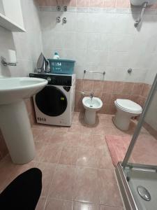 a small bathroom with a microwave and a toilet at perla house in Valledoria