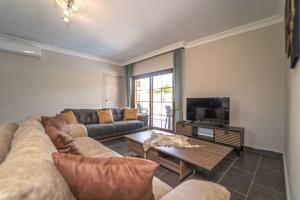 a living room with a couch and a tv at VİLLA Terasa in Fethiye