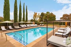 a swimming pool with lounge chairs and umbrellas at The Westin Sacramento Hotel & Marina in Sacramento