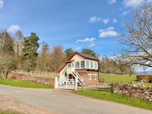a red and white brick house in a field at The Signal Box at Cliburn Station in Penrith