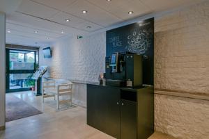 a coffee shop with a blackboard on the wall at Hotel Mondial Comfort - Frankfurt City Centre in Frankfurt
