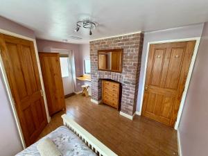 a room with a brick fireplace and two wooden doors at The Signal Box at Cliburn Station in Penrith
