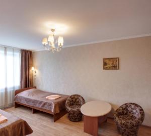 ヤロスラヴリにあるHotel Touristのベッド、テーブル、椅子が備わる客室です。