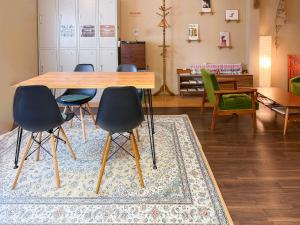 a dining room with a table and chairs on a rug at Suzuki Guesthouse in Kyoto